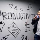 man with phone in front of wall art