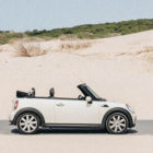 weißes Mini Cabrio vor einer Sanddüne