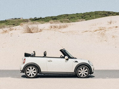 weißes Mini Cabrio vor einer Sanddüne